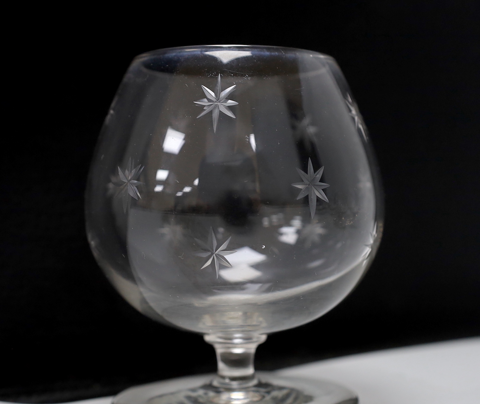 A set of seven cut glass brandy balloon glasses, with pattern of stars to each, 10.5cm high